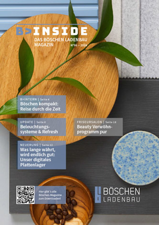 Titelseite des Böschen Ladenbau Magazins mit dekorativen Mustertellern, Kaffeebohnen und grünen Zweigen als Stillleben-Arrangement.